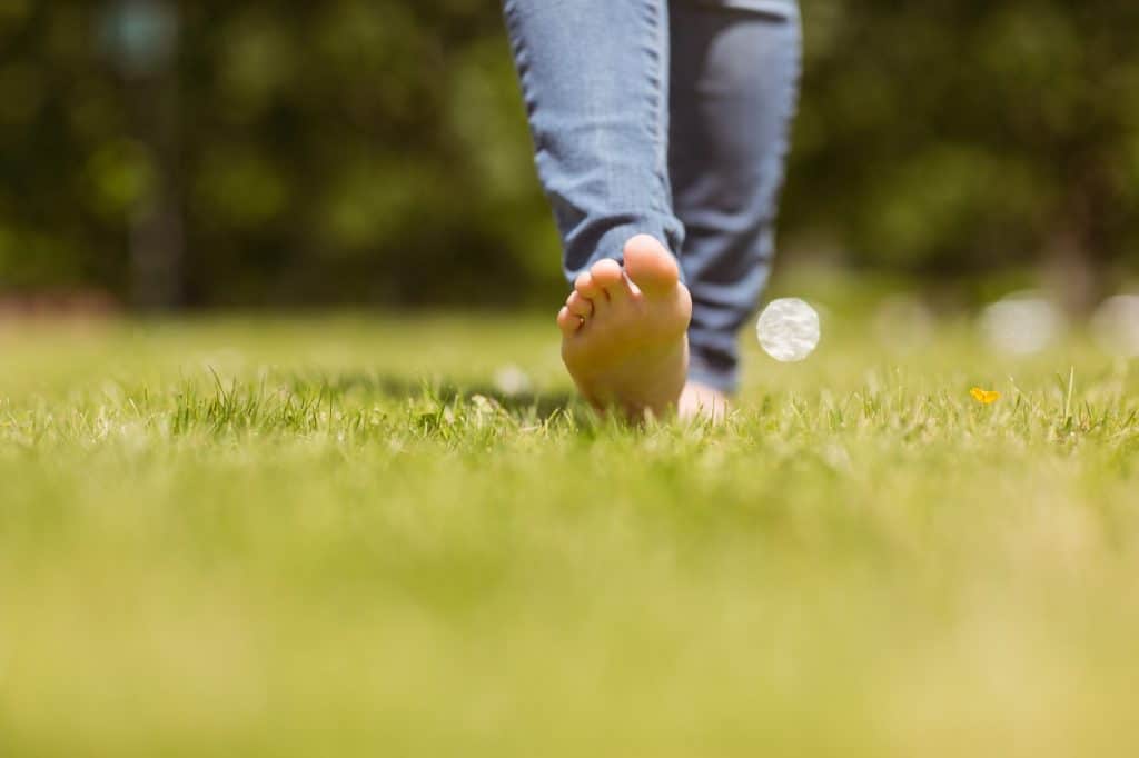 Close up of pretty redhead walking on grass at sunshine