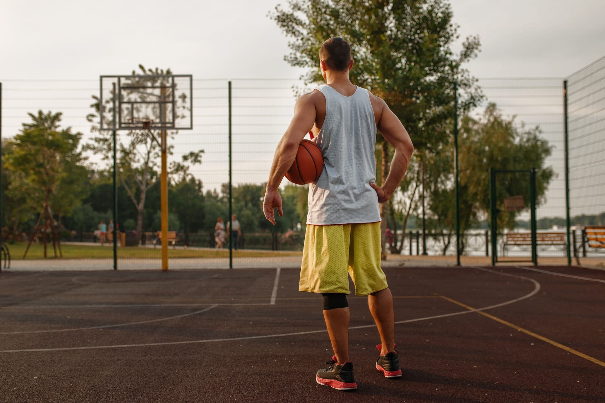 Muscular basketball player on outdoor court