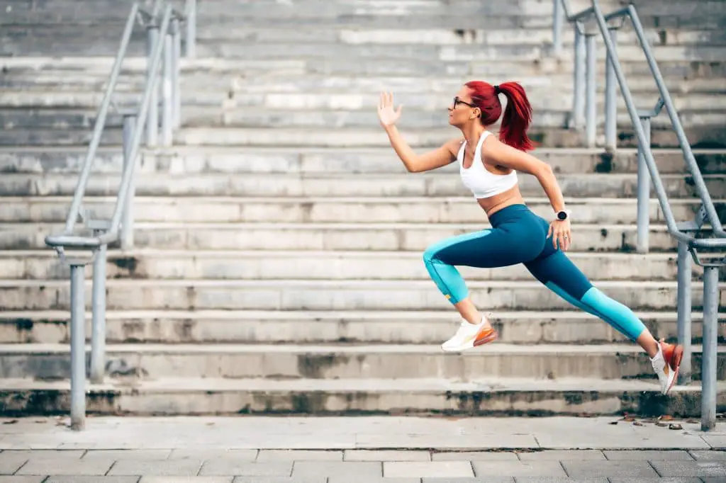 Portrait of woman jumping and running during cardio training