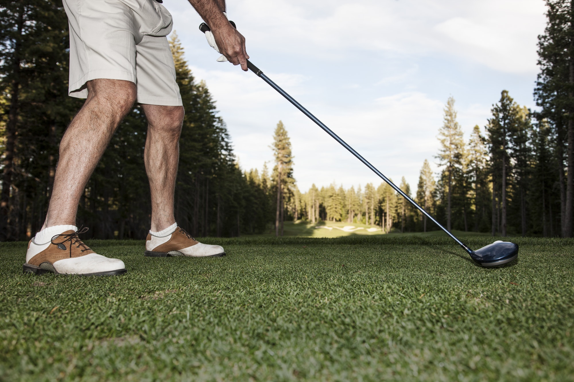 Senior golfer teeing off during a round of golf.