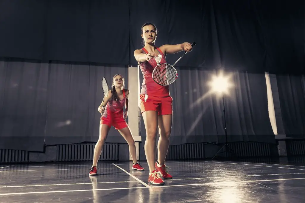 Young women playing badminton at gym