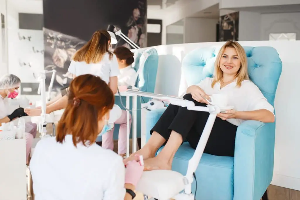 Two women on pedicure procedure in beauty salon