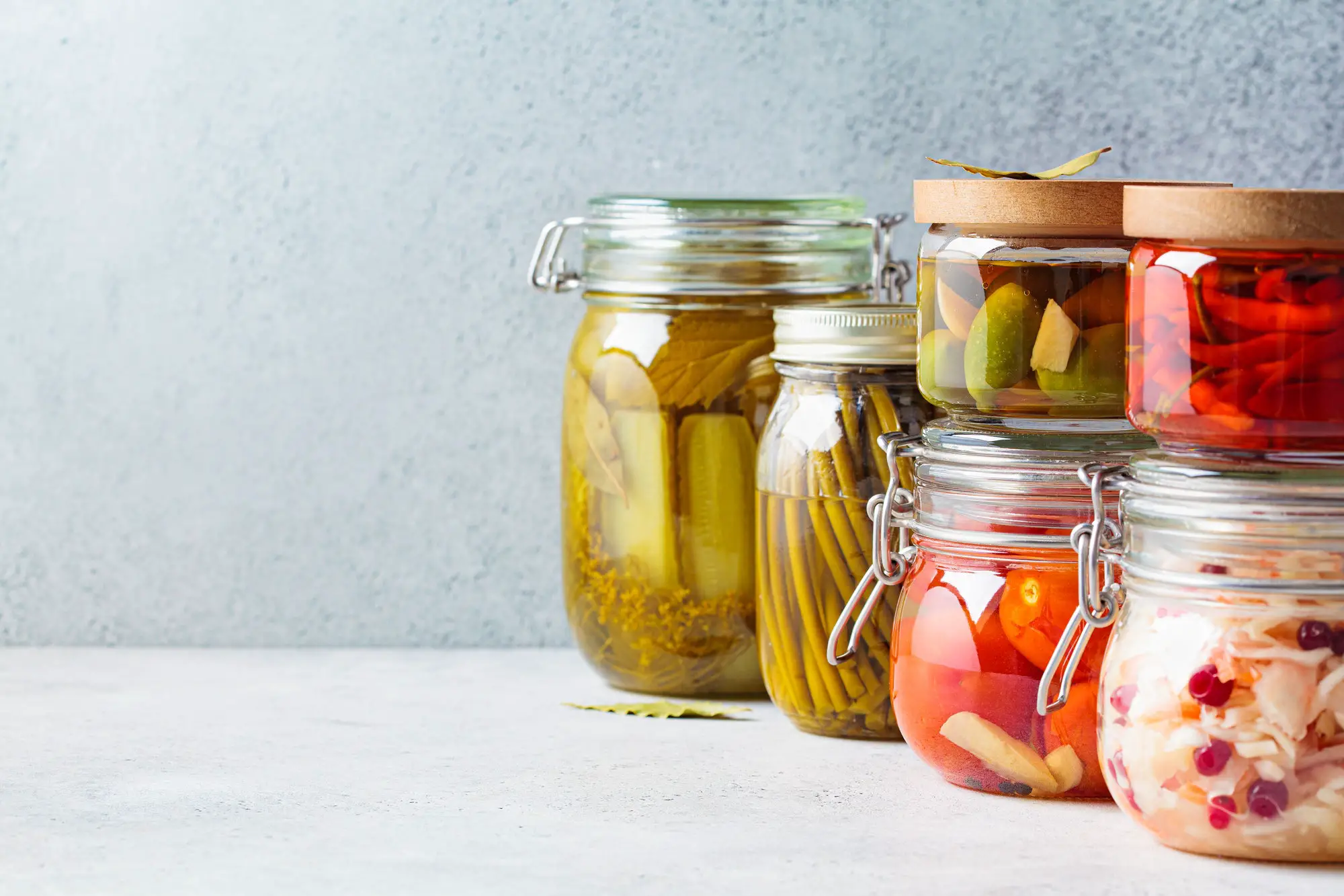 Homemade pickled and fermented vegetables in glass jars, copy space. Home preservation concept.