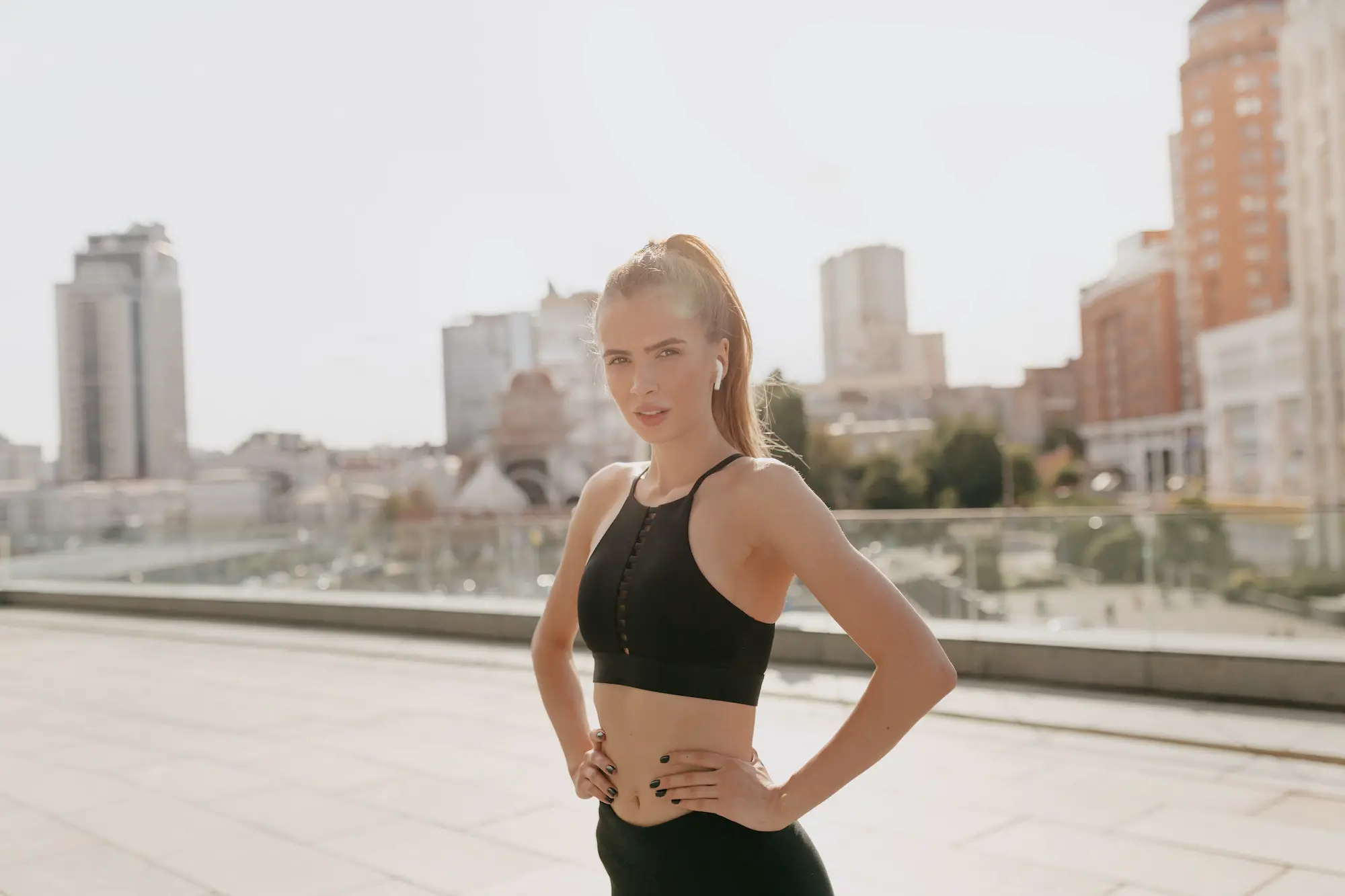 Healthy fit woman sprinter, running on city background wearing in the sportswear