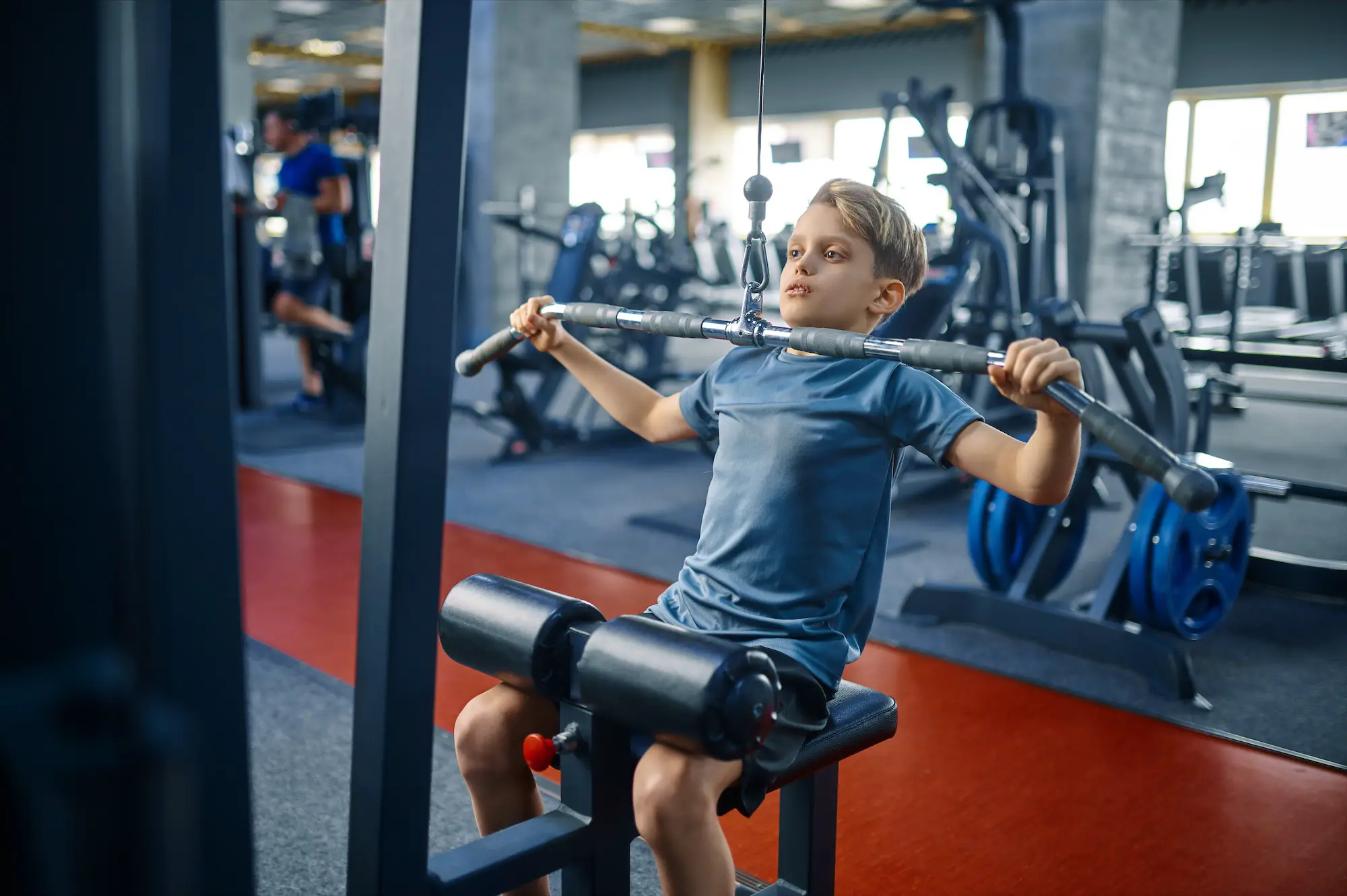 Boy on exercise machine, training in gym