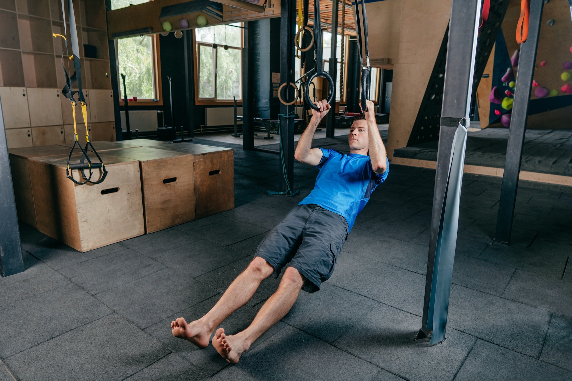 Young man training in a gym doing pull-ups